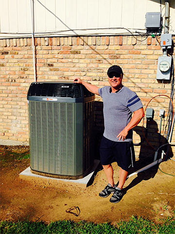 Performance Heat and Air technician standing by a newly installed unit