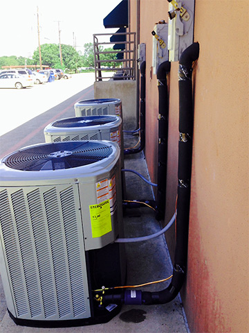 Residential AC units lining building