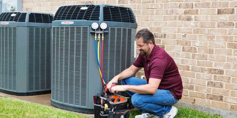 Service technician conducting inspection on air conditioning unit