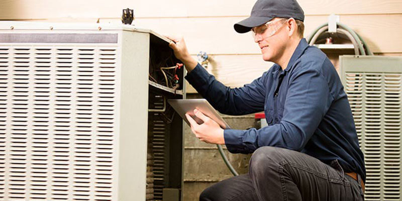 Service technician checking air conditioner parts